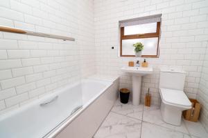 uma casa de banho branca com uma banheira e um lavatório em Business friendly & Spacious 2BR home - Perfectly located for working in Swansea em Swansea
