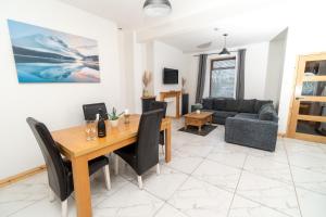 uma sala de estar com uma mesa de madeira e um sofá em Business friendly & Spacious 2BR home - Perfectly located for working in Swansea em Swansea