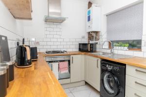 y cocina con lavadora y secadora. en Business friendly & Spacious 2BR home - Perfectly located for working in Swansea, en Swansea
