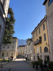una calle en una ciudad con edificios y un árbol en Palazzo 7, en Domodossola