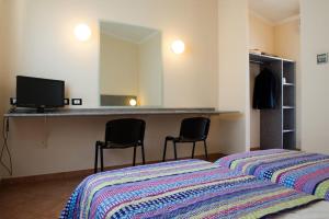 1 dormitorio con cama, espejo y sillas en Autohotel Ravenna, en Rávena
