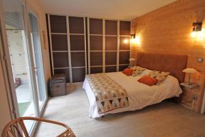 een slaapkamer met een bed en een houten muur bij La maison de l'auzette in Limoges