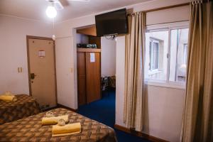 una camera d'albergo con due letti e una finestra di Hotel Pacífico a Mendoza
