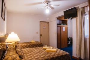 a hotel room with two beds and a ceiling fan at Hotel Pacífico in Mendoza