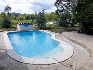 a large swimming pool with a hose in a yard at Chez Franck in Saint-Martin-de-Valgalgues