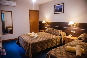 Hotel Pacífico في ميندوزا: غرفة فندقية بسريرين ومرآة