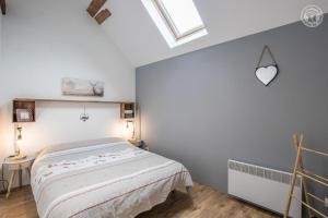 a white bedroom with a bed and a skylight at Gite la Montagnette in Ruffieux