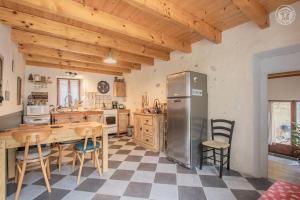kuchnia z lodówką, stołem i krzesłami w obiekcie Gite la Montagnette w mieście Ruffieux