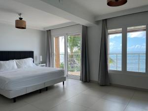 a bedroom with a bed and a view of the ocean at Sunset Surf Villa Beacon Hill in Simpson Bay