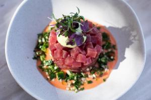 a plate of food with watermelon and greens on it at The Westin Resort, Costa Navarino in Romanu