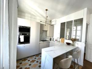 een keuken met witte kasten en een tafel en stoelen bij Charmant appartement au centre de Tours in Tours