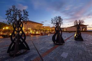 a group of trees in a courtyard at night at The Westin Resort, Costa Navarino in Romanu