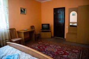 um quarto com uma cama e uma televisão e um quarto em Avalon em Kremenchuk