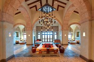 a large room with a bed and a chandelier at The Westin Resort, Costa Navarino in Romanu