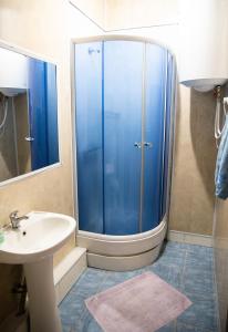 ein Badezimmer mit einer blauen Dusche und einem Waschbecken in der Unterkunft Avalon in Krementschuk