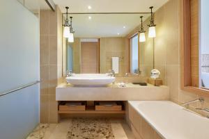 a bathroom with a sink and a tub and a mirror at The Westin Resort, Costa Navarino in Romanós