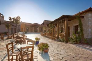 a row of tables and chairs in front of a building at The Westin Resort, Costa Navarino in Romanu