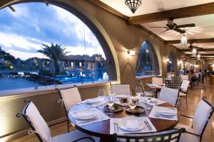 a dining room with a table and chairs and a large window at The Westin Resort, Costa Navarino in Romanu