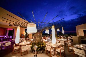 a restaurant with white tables and chairs and a ceiling at The Westin Resort, Costa Navarino in Romanu