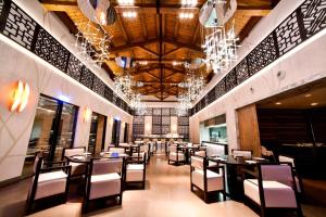 a dining room with tables and chairs and chandeliers at The Westin Resort, Costa Navarino in Romanu