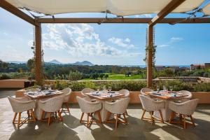 un grupo de mesas y sillas en un patio en The Westin Resort, Costa Navarino en Romanós