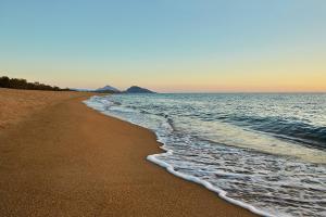uma praia com a maré a chegar em The Westin Resort, Costa Navarino em Romanu