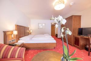 een hotelkamer met een bed en een televisie bij Hotel Sportalmmm, Hoch-Genuss in Zauchensee
