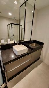 a bathroom with a sink and a mirror at Estúdio Aconchegante no 24º andar do Ed. Vertigo. in Campo Grande