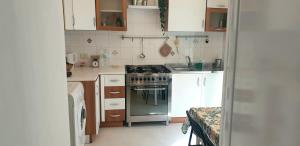 a small kitchen with a stove and white cabinets at Regina Elena al mare in Pescara