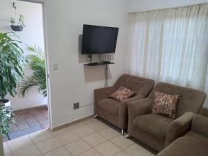 sala de estar con sofá y TV de pantalla plana en Hogar dulce hogar!, en San Miguel