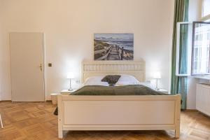 1 dormitorio con 1 cama y una pintura en la pared en Large 4BR Apt Near Karlsplatz Ideal for Big Groups, en Viena