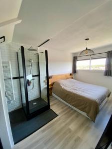 a bedroom with a bed and a glass shower at Sunset lovers in Lacanau-Océan