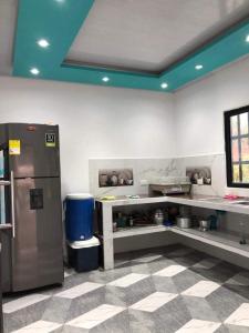 a kitchen with a counter and a refrigerator in a room at Parcela el paraiso in Doradal