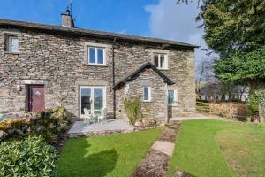 an exterior view of a stone house with a yard at Willow, a luxury rural retreat in Staveley