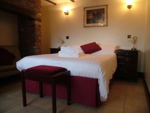 a bedroom with a large white bed and a chair at The Crown Hotel in Mundford