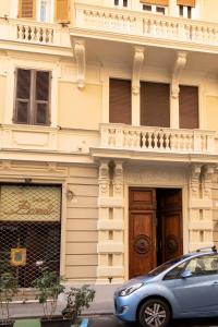 una macchina blu parcheggiata di fronte a un edificio di Granello Suite Central a Genova