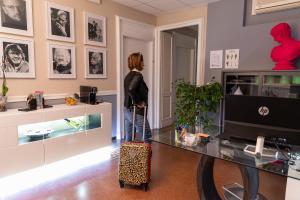 una donna in piedi in una stanza con una valigia di Granello Suite Central a Genova