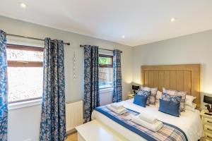 a bedroom with a bed with blue curtains at Bluebell Lodge 7 with Hot Tub in Newton Stewart