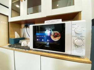 a microwave oven sitting on a counter with a pizza at Hotel 91 Taman Daya in Johor Bahru