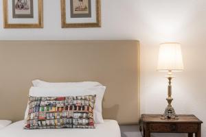 ein Bett mit einem Kissen und einem Tisch mit einer Lampe in der Unterkunft GuestReady - Office Residence 3 in Porto