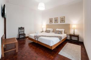 ein Schlafzimmer mit einem Bett, einem Tisch und einem Stuhl in der Unterkunft GuestReady - Office Residence 3 in Porto