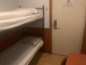 a small room with two bunk beds and a door at Hotel Continental Amsterdam in Amsterdam