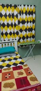 a bedroom with a bed and a checkered curtain at Homestay Lumut in Lumut