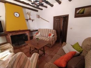 sala de estar con sofá y chimenea en Cortijo Los Petronilos, en Las Lagunillas