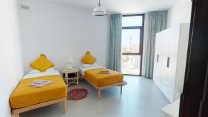 a room with two beds and a window at St Julians Central luxury apartment in St. Julianʼs