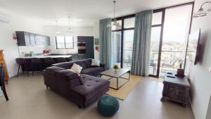 a living room with a couch and a kitchen at St Julians Central luxury apartment in St. Julianʼs