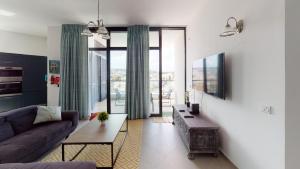 - un salon avec un canapé et une table dans l'établissement St Julians Central luxury apartment, à San Ġiljan