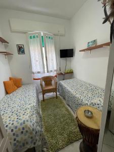 a bedroom with two beds and a table and a chair at La stanza di Giuly in Porto Santo Stefano