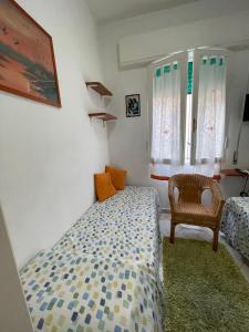 a small bedroom with a bed and a chair at Giuly's Room in Porto Santo Stefano