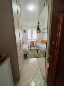 a hallway with a bedroom with a bed and a chair at Giuly's Room in Porto Santo Stefano
